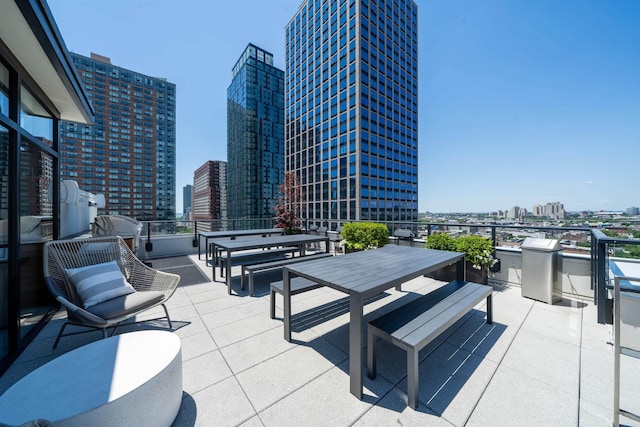 view of patio featuring a view of city, outdoor dining area, and area for grilling