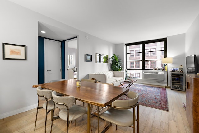 dining room with light wood finished floors, baseboards, and cooling unit