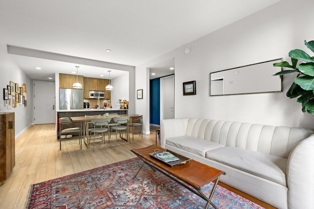 living room with light wood finished floors, baseboards, and recessed lighting