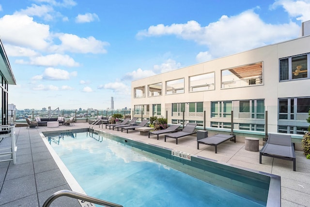 view of pool with a view of city and a patio area