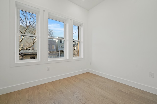 unfurnished room featuring light wood finished floors and baseboards