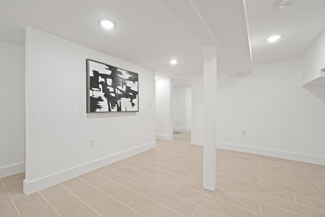 finished below grade area featuring recessed lighting, baseboards, and wood finish floors