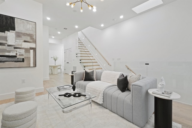 living room featuring recessed lighting, stairway, a skylight, and light wood finished floors