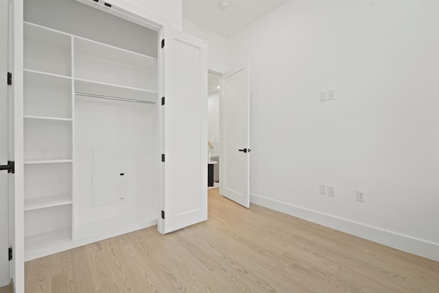 unfurnished bedroom featuring a closet, baseboards, and wood finished floors