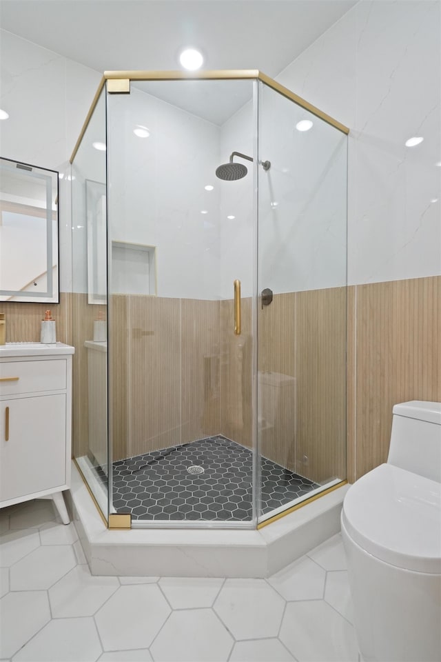 bathroom featuring tile patterned flooring, toilet, vanity, and a stall shower