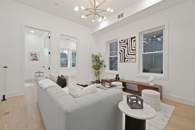 living room featuring visible vents, baseboards, and light wood-style floors