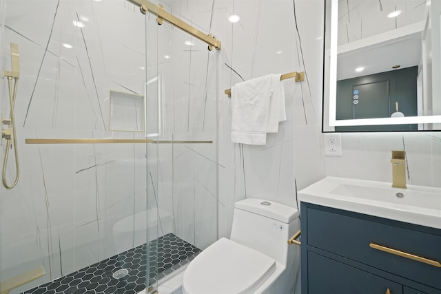 bathroom with vanity, tile walls, toilet, and a marble finish shower