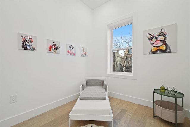 living area with baseboards and light wood finished floors