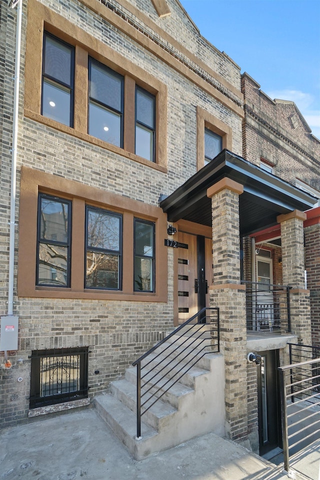 view of exterior entry featuring brick siding