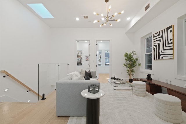 living room with light wood finished floors, visible vents, recessed lighting, and a skylight