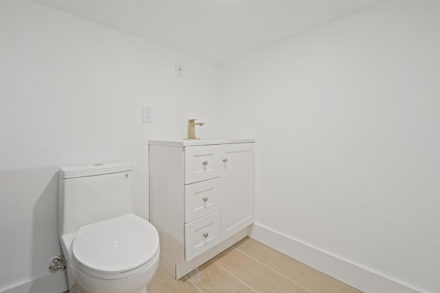 half bathroom featuring a sink, baseboards, and toilet