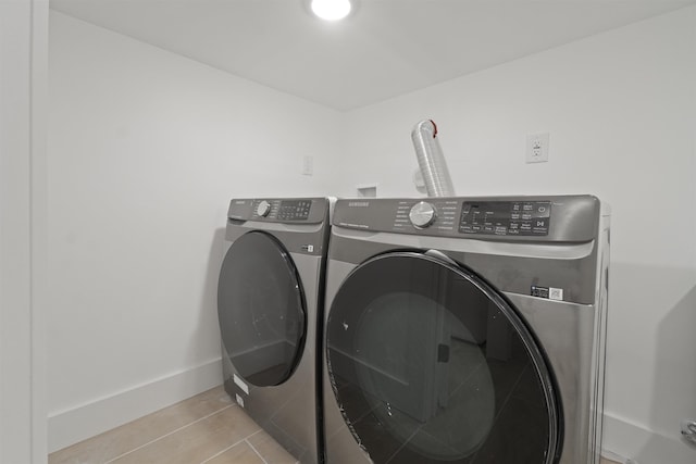 laundry area with baseboards, separate washer and dryer, and laundry area