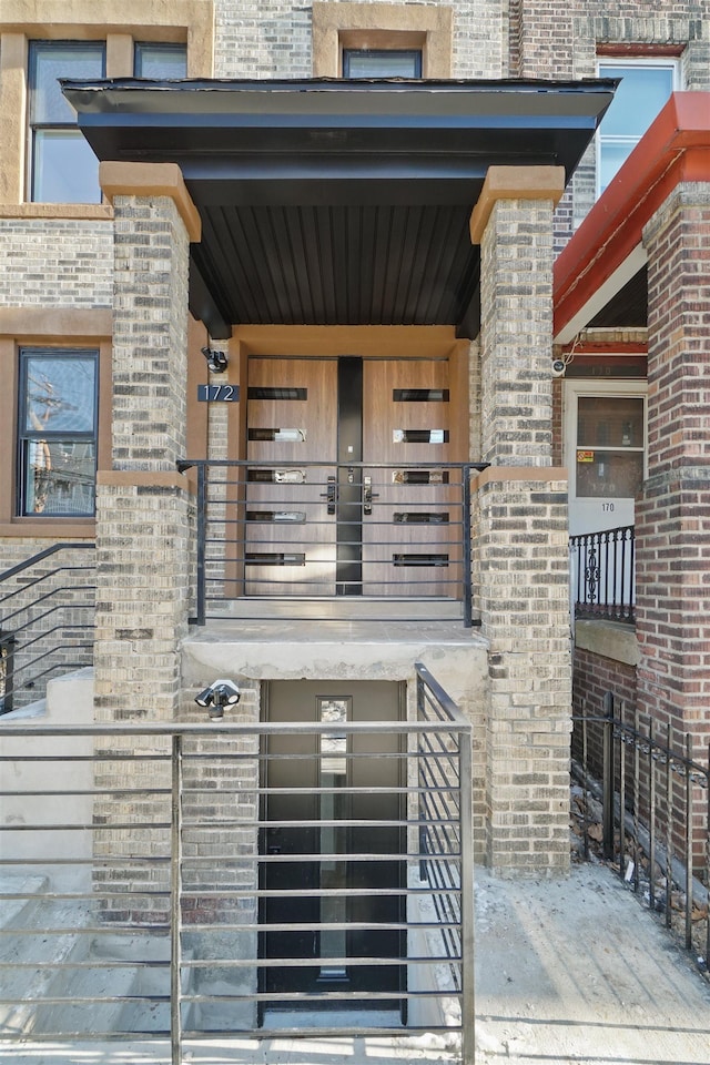 view of exterior entry featuring brick siding