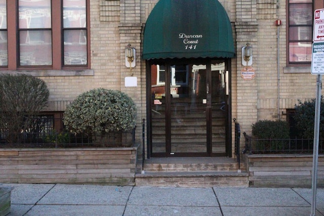 doorway to property featuring brick siding