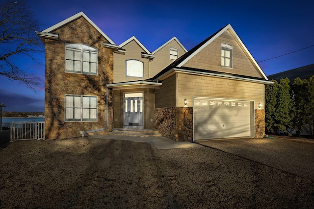 traditional-style home featuring stone siding and driveway