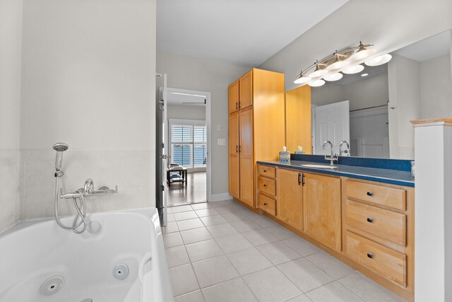 full bathroom with a whirlpool tub, tile patterned flooring, and vanity