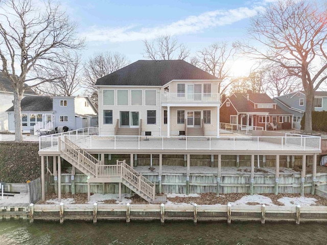 rear view of house featuring a water view and stairway