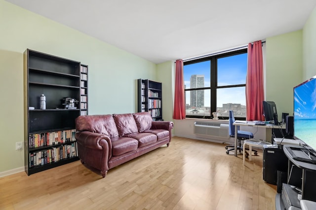 living room with light hardwood / wood-style flooring and a wall mounted air conditioner