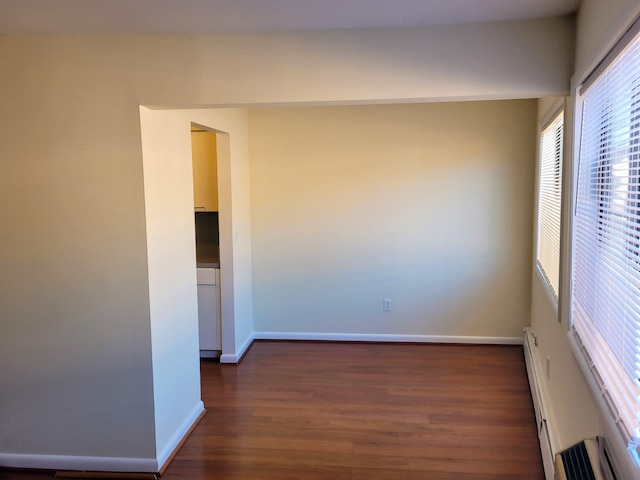 empty room featuring dark hardwood / wood-style floors and baseboard heating