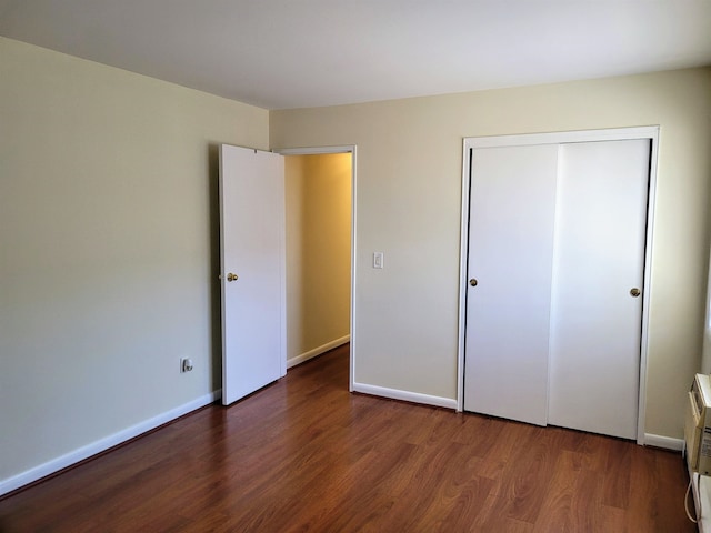 unfurnished bedroom featuring dark hardwood / wood-style floors and a closet