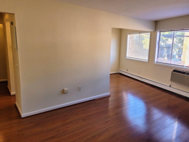 spare room with a baseboard radiator and dark hardwood / wood-style floors