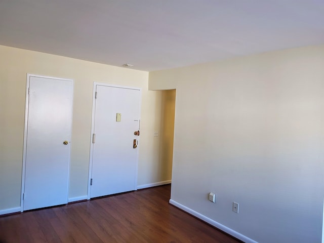 spare room with dark wood-type flooring