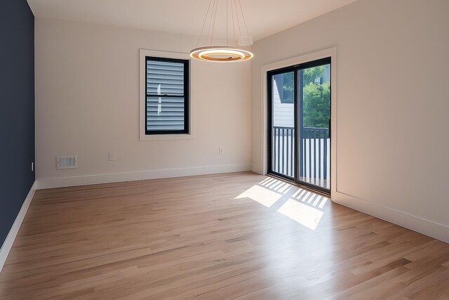 141 Sherman Ave Unit 1, Jersey City, NJ 07307 - spare room featuring a chandelier and light wood-style flooring