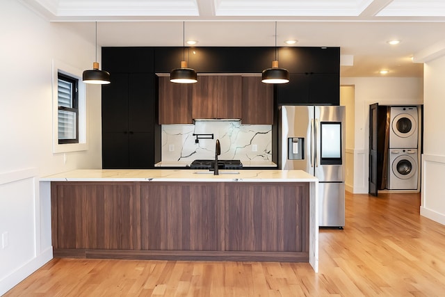 141 Sherman Ave Unit 1, Jersey City, NJ 07307 - kitchen with stainless steel fridge with ice dispenser, estacked washer and dryer, modern cabinets, light wood-style floors, and crown molding