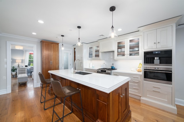 249 Grove St Unit 1, Jersey City, NJ 07302 - kitchen with light countertops, ornamental molding, tasteful backsplash, an island with sink, and light wood-type flooring