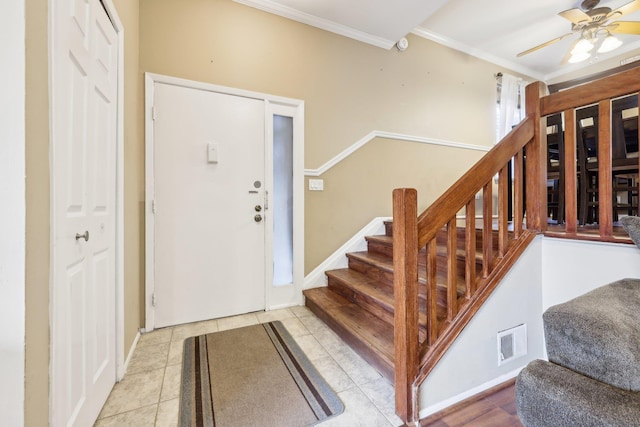 entrance foyer featuring ceiling fan, tile patterned floors, and crown molding