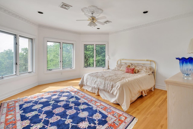 bedroom with hardwood / wood-style floors, ceiling fan, and crown molding