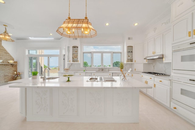 kitchen featuring a center island with sink, pendant lighting, sink, white cabinets, and stainless steel gas cooktop