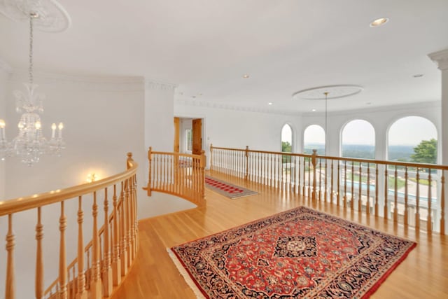 hall with light hardwood / wood-style floors and an inviting chandelier