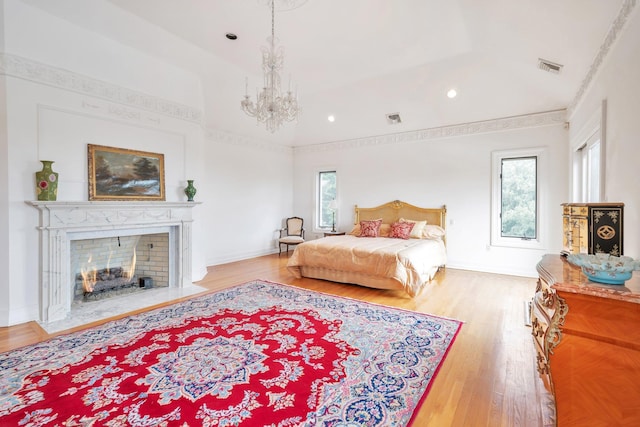 bedroom featuring a chandelier, multiple windows, and light hardwood / wood-style floors