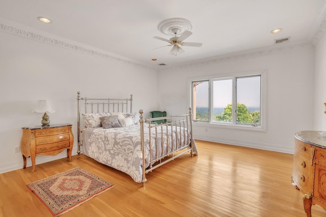 bedroom with ceiling fan, light wood-type flooring, and crown molding