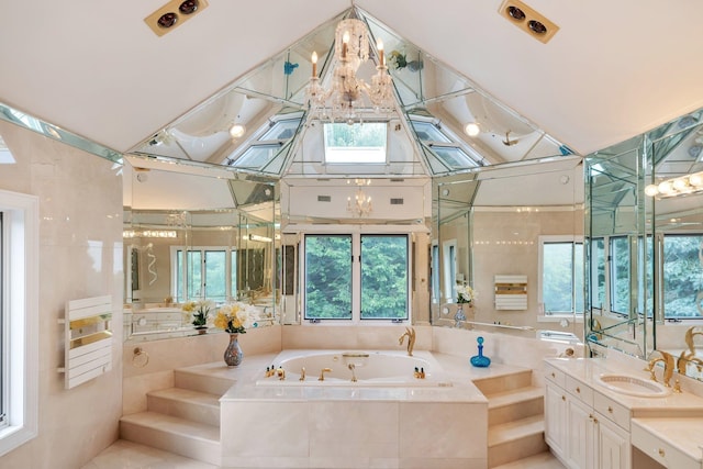 bathroom with tiled bath, vanity, and an inviting chandelier