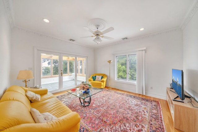 living room with ceiling fan, hardwood / wood-style floors, ornamental molding, and french doors