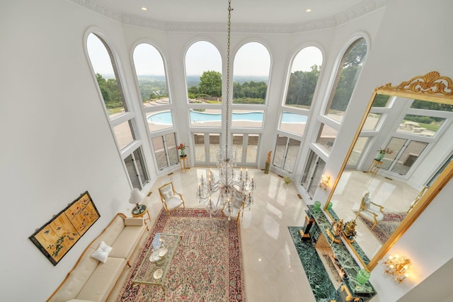 living room with ornamental molding, plenty of natural light, and a high ceiling