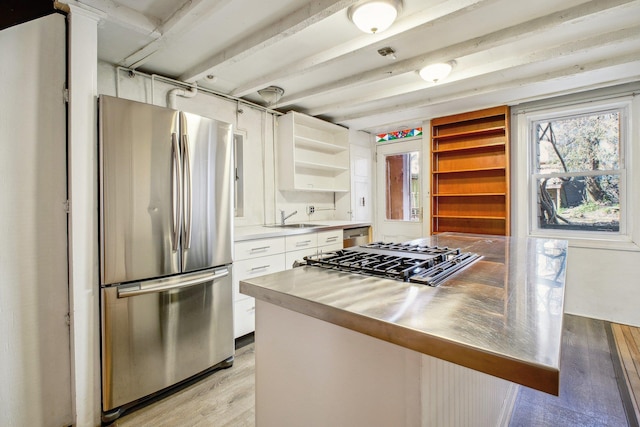 kitchen with light wood-style flooring, stainless steel appliances, white cabinetry, open shelves, and a sink