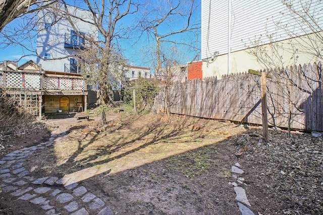 view of yard featuring fence and a wooden deck