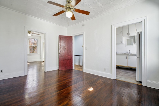 unfurnished bedroom with an ornate ceiling, wood-type flooring, baseboards, and freestanding refrigerator