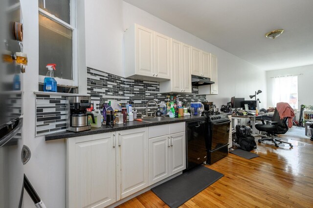228 1st St Unit 3B, Jersey City, NJ 07302 - kitchen with dishwasher, under cabinet range hood, a sink, light wood-style flooring, and backsplash