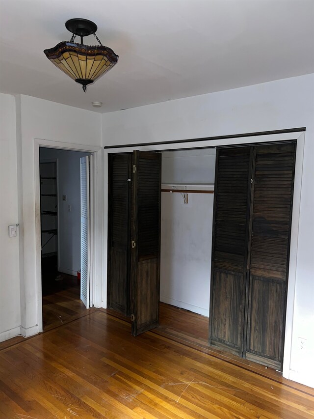 unfurnished bedroom with a closet and hardwood / wood-style flooring