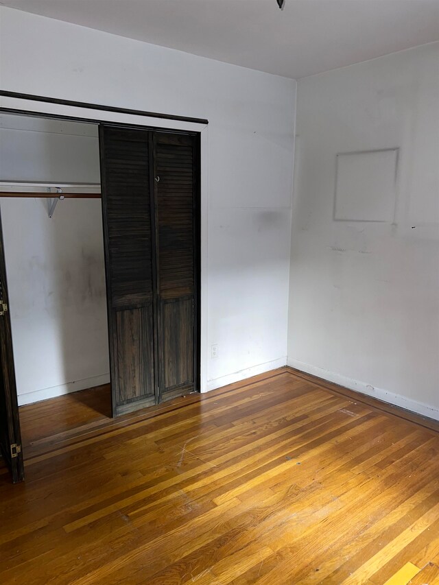 unfurnished bedroom featuring wood-type flooring and a closet