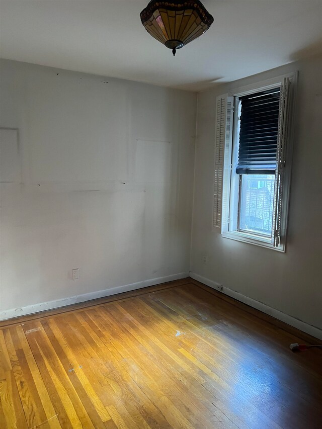 unfurnished room with wood-type flooring