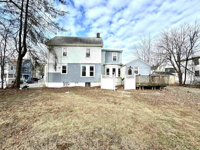 rear view of property with a yard and a wooden deck