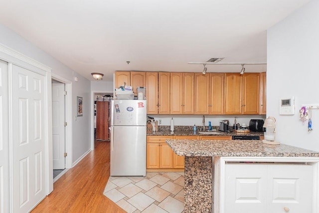354 3rd St Unit 3, Jersey City, NJ 07302 - kitchen with freestanding refrigerator, light wood-style floors, light stone countertops, and rail lighting
