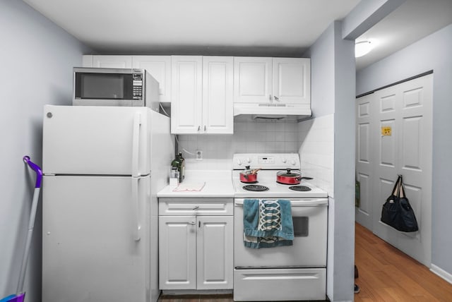 kitchen featuring backsplash, white refrigerator, range with electric stovetop, white cabinetry, and wood-type flooring