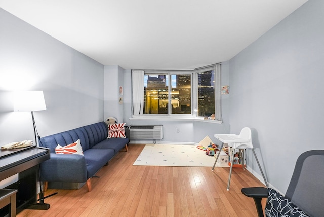 living area featuring a wall mounted air conditioner and light wood-type flooring