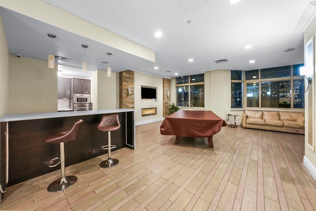 game room featuring a wall of windows, light wood-type flooring, and pool table